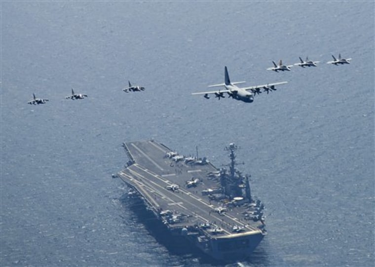 Planes fly in formation over the aircraft carrier USS George Washington in the seas east of the Korean peninsula on July 27. U.S. and South Korean ships got into position in the Yellow Sea on Sunday for the four-day exercise, said Cmdr. Jeff Davis, spokesman for the 7th Fleet in Yokosuka, Japan. 